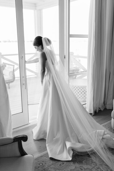 black and white photo of bride in front of window