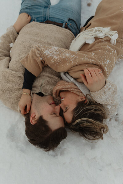 couple embraces in snow for couples photos in pei