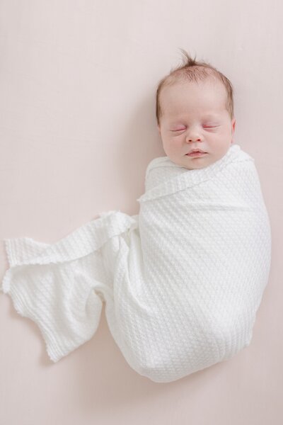 Newborn being cradled in his father's arms.