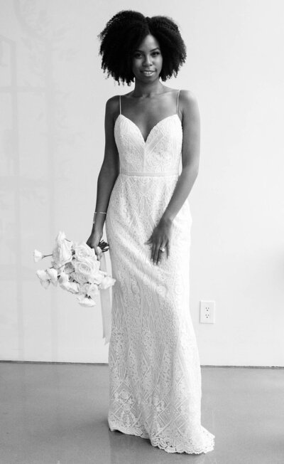 young attractive black bride with natural hair holding a bouquet.