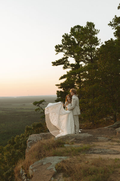a couple standing on a cliff at Petit Jean State Park during their Arkansas destination elopement.