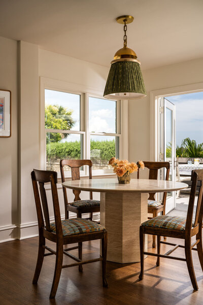 Teal blue dining room side board with bold wallpaper and barware
