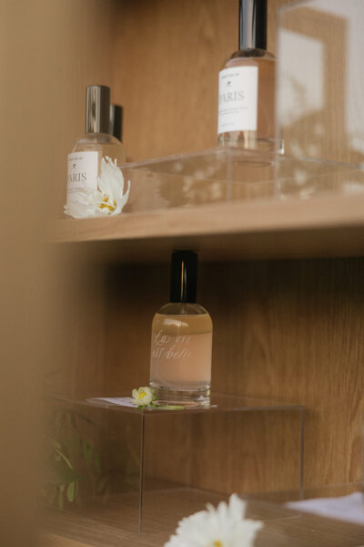 Custom fragrance bottles on white oak shelves