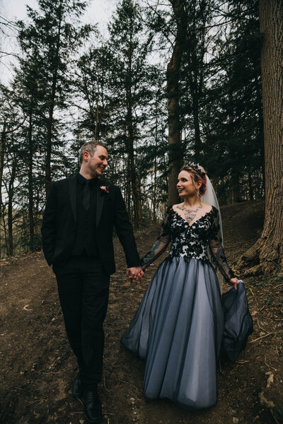 Gothic couple walk through Squires Castle Forest