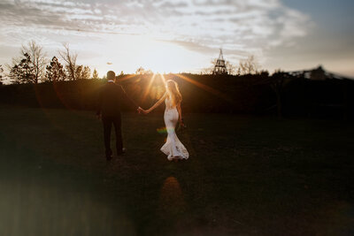 newlywed couple waling away in the sunset