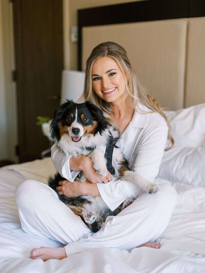 Bride poses with dog during getting ready photos at luxury Vail, Colorado wedding