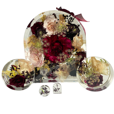 pink and burgundy funeral casket flowers laying on top of a casket