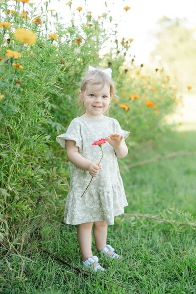 summer-family-floral-minis-by-nashville-family-photographer-dolly-delong-perry-family-farm-in-nashville-august-floral-minis-a--picture-of-a-girl-holding-flowers-in-a-wildflower-field