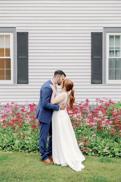 Bride and groom kissing in front of wedding venue