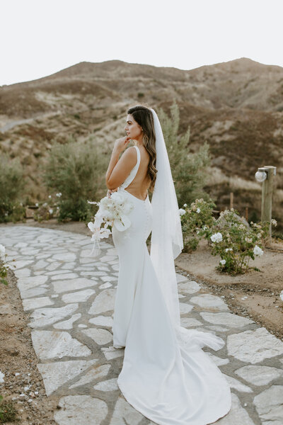 bride looking over her shoulder holding a bouquet