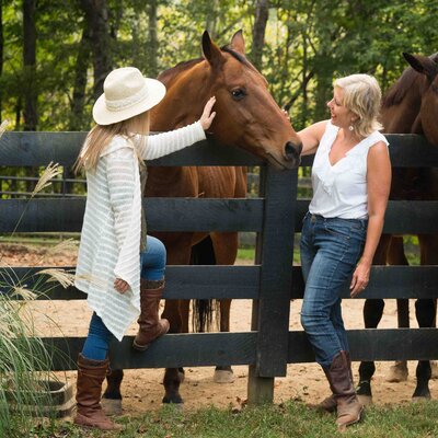 Group of women engaging with horses in a shared healing session outdoors in the Berkshires