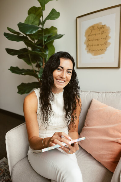 Lizzy smiling while holding a notebook