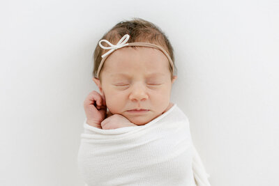 newborn baby girl wearing bow photographed by South Jersey Newborn Photographer Tara Federico