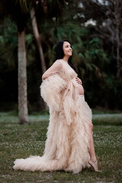 couple on wooden fence at a preserve posing for maternity pictures