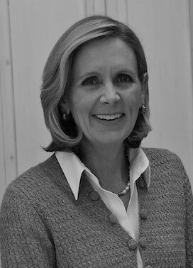 lack and white headshot of a professional Mary Folsom wearing a sweater and pearl necklace.