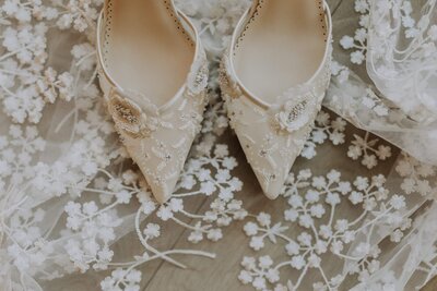Lace bridal shoes on top of lace veil