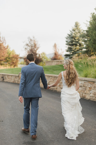 bride and groom walking down street at spruce mountain ranch