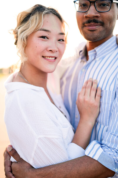 Engaged couple smiles during their engagement session at the Crescent Hill Reservoir