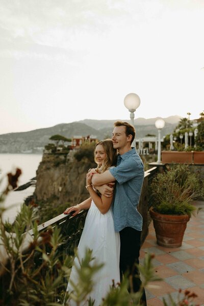 Engagement shoot of couple looking out over the coast.