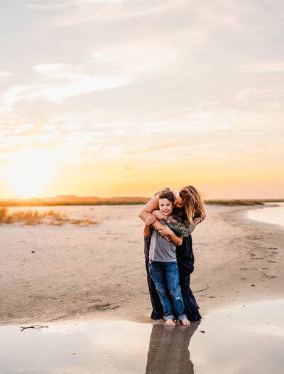 Mother embraces her son during Family Photos on Folly Beach in Charleston, SC.