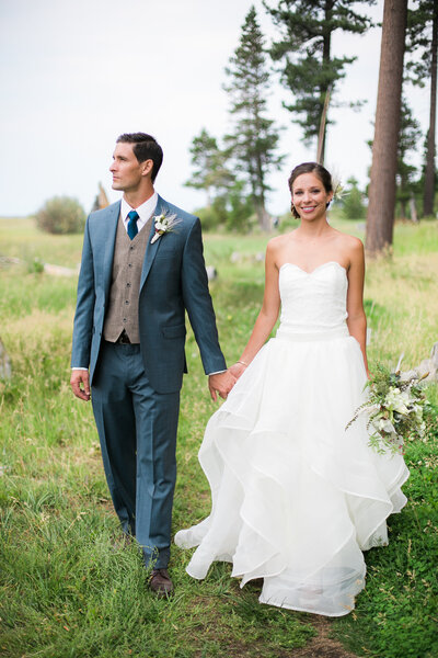 Bride and groom walk through meadow during wedding day in Lake Tahoe CA.