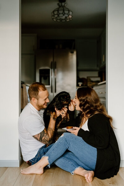 couple poses on floor with dog