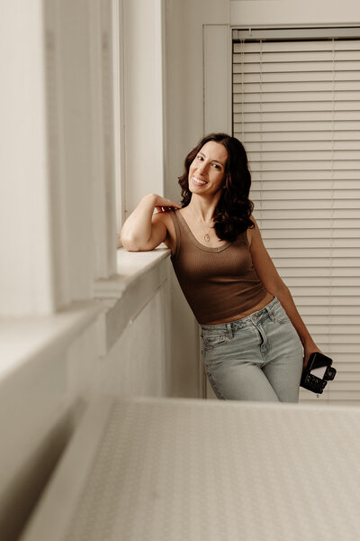 NJ photographer smiling and holding her camera