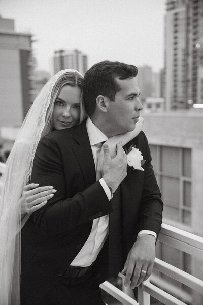 bride and groom embrace on san diego rooftop after wedding ceremony
