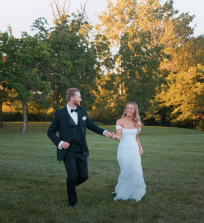 a bride and groom running through the grass together