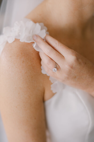 Delaware wedding bride holding sleeve of dress at Greenville Country Club Wilmington