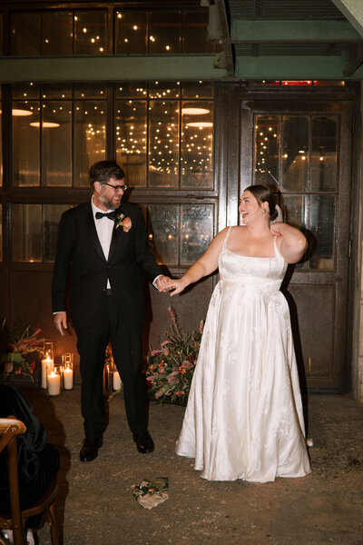 Flash photo of bride and groom holding hands and smiling at each other