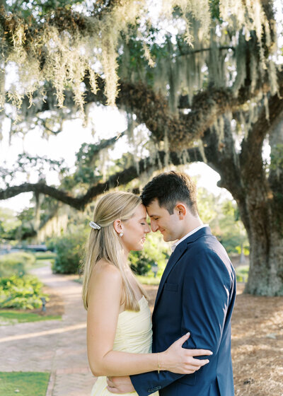 an engaged couple sitting on a bench together