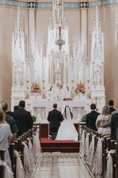 bride and groom at the altar while priests speaks