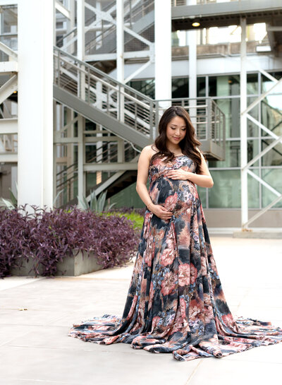 pregnant woman holding belly blue floral dress