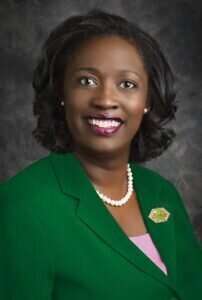 headshot of Myra McKenzie-Harris wearing a green blazer with a pink blouse