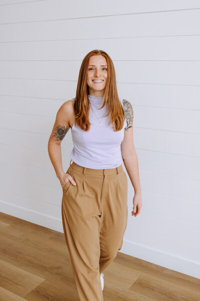 Event planner in cozy winter outfit and grey beanie smiling in snowy Banff forest – Rocky Mountain Wedding Collective