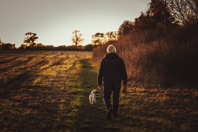 Man walking with his dog after engaging in healthy habits to support his trauma healing