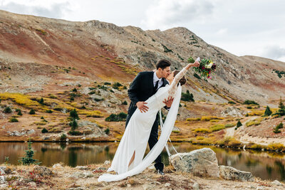 Colorado Elopement Photographer captures couple walking through field holding hands while walking through field
