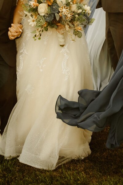Closeup photo of bride's gown and bouquet.