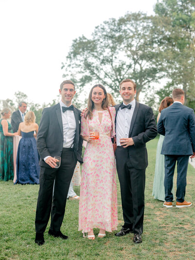 A grip and grin group photo of wedding guests on the lawn of Rosecliff Mansion during cocktail hour.