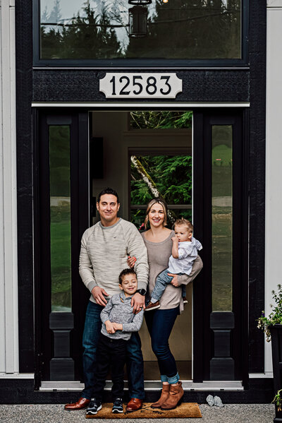 Family of four standing in the doorway of their home in Pitt Meadows.