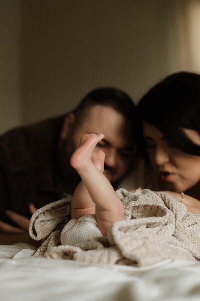Parents admiring their newborn’s tiny feet, a glimpse into the everyday wonder of new life.