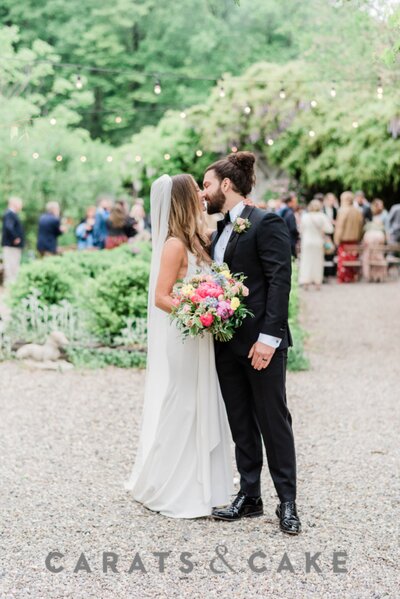 Newlyweds at their wedding reception with lights twinkling in the background