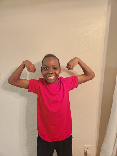 a young boy showing his arm muscles