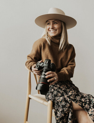 photography student, woman wearing a cowgirl hat and holding a camera