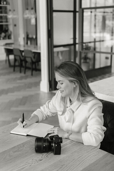 Portrait of Katya Joseph, London wedding photographer, writing in her notebook