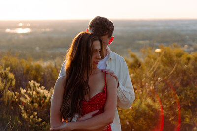 Silhouette of couple facing each other holding their hands between them & girl popping her foot