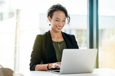 Professional woman working on laptop happy with career clarity