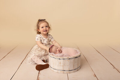 toddler posing with baby by Philadelphia Newborn Photographer