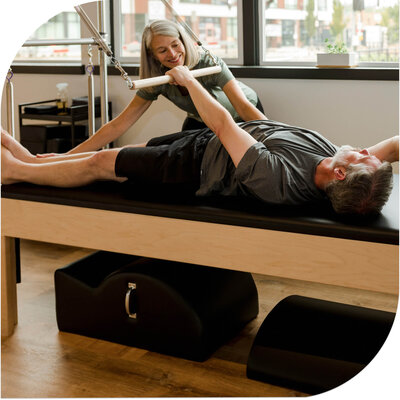 Roll down exercise on cadillac during a private lesson at Milwaukie Pilates